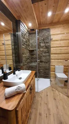 a bathroom with a sink and a shower and a toilet at Baśniowy Domek Kolędówka z jaskinią SPA - Osada Jaworzyny in Tokarnia