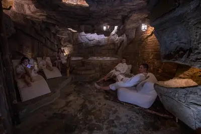 a group of people sitting on beds in a cave at Baśniowy Domek Kolędówka z jaskinią SPA - Osada Jaworzyny in Tokarnia