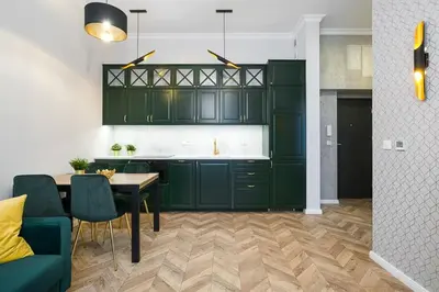 a kitchen with green cabinets and a table and chairs at Glamorous Apartment Old Town Cracow in Kraków