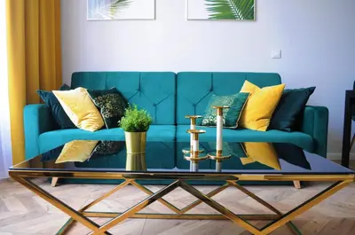 a blue couch with yellow pillows and a coffee table at Glamorous Apartment Old Town Cracow in Kraków