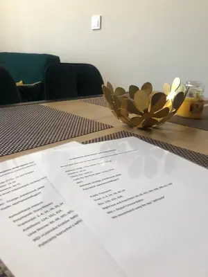 a table with a bowl of flowers and papers on it at Glamorous Apartment Old Town Cracow in Kraków