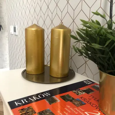 two gold candles on a table next to a magazine at Glamorous Apartment Old Town Cracow in Kraków