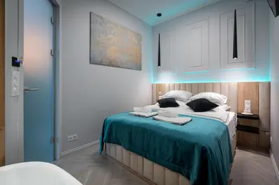 a bedroom with a large bed with a blue light at Dasto Apartments Old Town Kraków in Kraków
