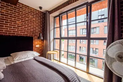 a bedroom with a bed and a large window at City Lights Kazimierz in Kraków