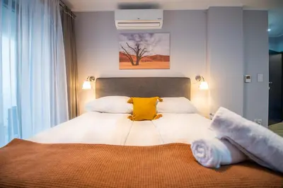 a bedroom with a white bed with two yellow pillows at City Lights Kazimierz in Kraków