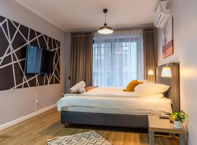 a bedroom with a large bed and a tv at City Lights Kazimierz in Kraków