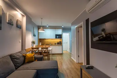 a living room with a couch and a dining room at City Lights Kazimierz in Kraków