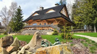 a house with a statue in front of it at Baśniowy Domek Groń z Jaskinią SPA - Osada Jaworzyny in Tokarnia