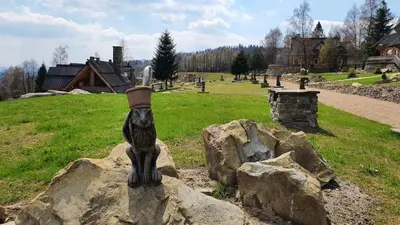 a statue of a cat on top of a rock at Baśniowy Domek Groń z Jaskinią SPA - Osada Jaworzyny in Tokarnia