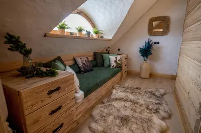 a living room with a green couch and a rug at Baśniowy Domek Groń z Jaskinią SPA - Osada Jaworzyny in Tokarnia
