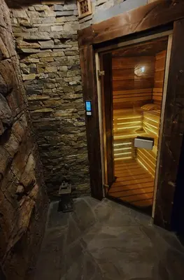 an empty sauna with a wooden door in a room at Baśniowy Domek Groń z Jaskinią SPA - Osada Jaworzyny in Tokarnia