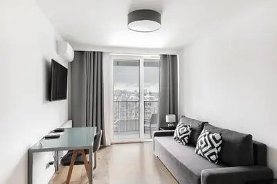 a living room with a table and a kitchen at Apartamenty Platinex 6 in Kraków