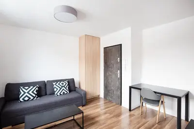 a white bathroom with a sink and a washing machine at Apartamenty Platinex 6 in Kraków