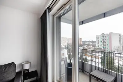 a room with a balcony with a large window at Apartamenty Platinex 6 in Kraków