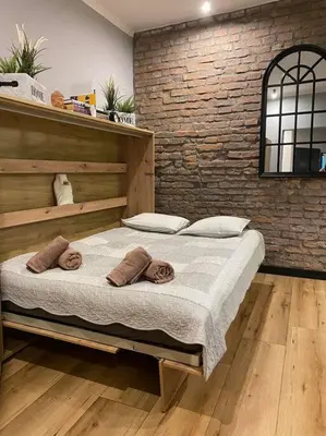 a bedroom with a large bed with towels on it at Zender Kazimierz Apartment in Kraków