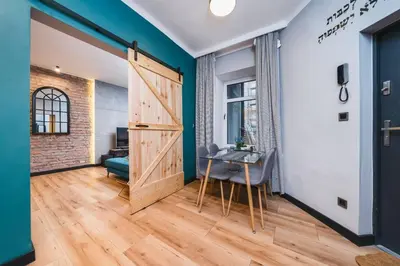 a room with a door and a table with a chair at Zender Kazimierz Apartment in Kraków