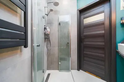 a shower with a glass door in a bathroom at Zender Kazimierz Apartment in Kraków