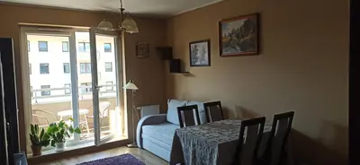 a dining room with a table and a blue couch at Apartamenty Kraków -Podgorze M&W in Kraków
