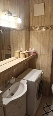 a bathroom with a washing machine and a sink at Apartamenty Kraków -Podgorze M&W in Kraków