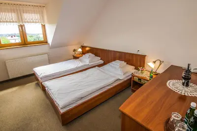 a bedroom with a large bed and a table at Gościniec Na Rozdrożu in Libiąż
