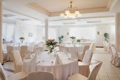 a banquet hall with white tables and white chairs at Gościniec Na Rozdrożu in Libiąż