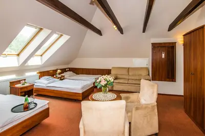 a bedroom with a bed and a couch and a table at Gościniec Na Rozdrożu in Libiąż