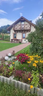 a house with a flower garden in front of it at Słoneczna Chałupka in Zawoja