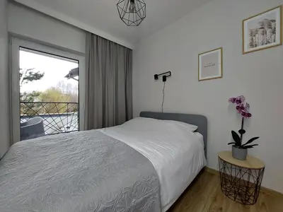a bedroom with a bed and a large window at MR HOME APARTMENTS - Limba in Kraków