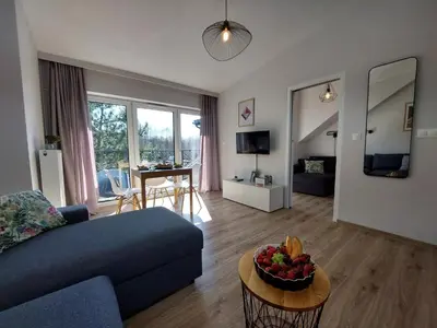 a living room with a couch and a bowl of fruit on a table at MR HOME APARTMENTS - Limba in Kraków