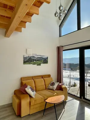 a living room with a couch and a large window at Cuda Natury - Niebo, Wiatr, Ziemia in Zawoja
