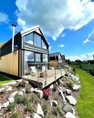 a modern house with a deck and windows at Cuda Natury - Niebo, Wiatr, Ziemia in Zawoja