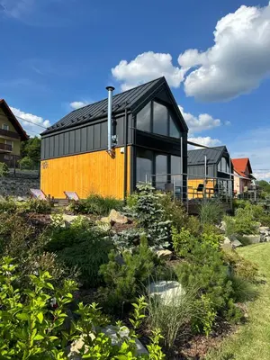 a black and yellow house in a garden at Cuda Natury - Niebo, Wiatr, Ziemia in Zawoja