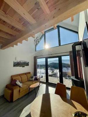 a living room with a couch and a large window at Cuda Natury - Niebo, Wiatr, Ziemia in Zawoja