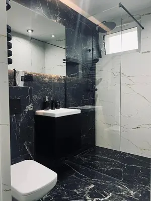 a black and white bathroom with a toilet and a sink at Apartamenty Modrzewiowa Zator in Piotrowice