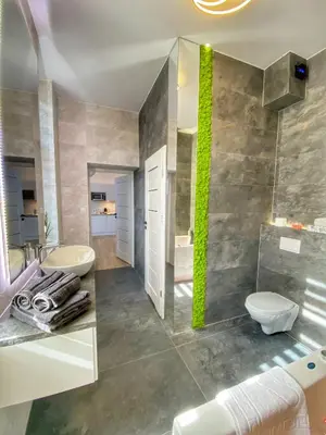 a bathroom with a sink and a toilet and a mirror at Apartament biały z jacuzzi in Kraków