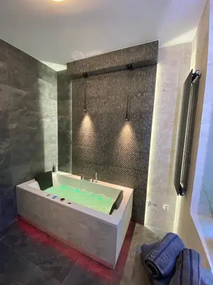 a bathroom with a bath tub with a shower at Apartament biały z jacuzzi in Kraków