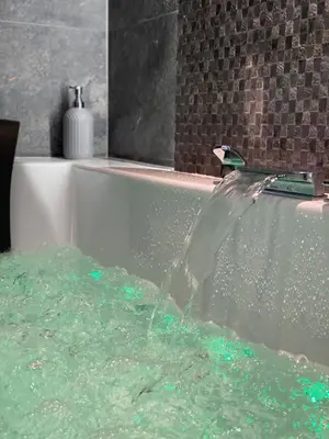 a bath tub with water coming out of a faucet at Apartament biały z jacuzzi in Kraków