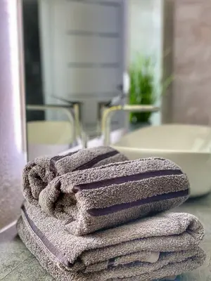 a pile of towels sitting on a counter in a bathroom at Apartament biały z jacuzzi in Kraków