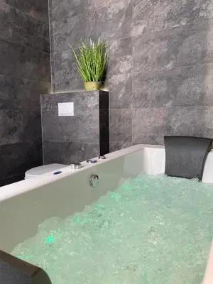a bath tub filled with water in a bathroom at Apartament biały z jacuzzi in Kraków