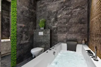 a bathroom with a bath tub with a toilet and a bath tub at Apartament biały z jacuzzi in Kraków