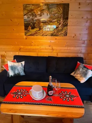 a living room with a blue couch with a table at LEŚNE ZACISZE OCHOTNICA in Ochotnica Górna