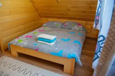 a small bed in a wooden room with towels on it at LEŚNE ZACISZE OCHOTNICA in Ochotnica Górna