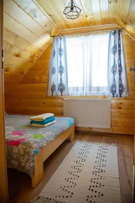 a bedroom with a bed in a wooden house at LEŚNE ZACISZE OCHOTNICA in Ochotnica Górna