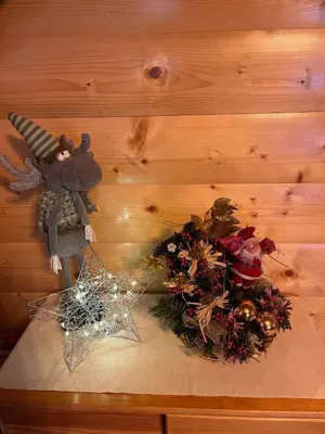 a wooden table with a christmas decoration and a basket of flowers at LEŚNE ZACISZE OCHOTNICA in Ochotnica Górna