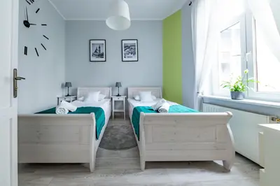 two beds in a bedroom with green and white at Wawel Castle Apartment in Kraków