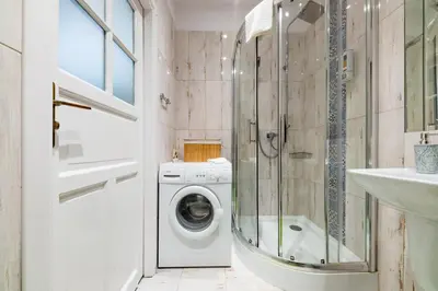 a bathroom with a washing machine and a shower at Wawel Castle Apartment in Kraków