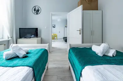 a bedroom with two beds and a tv and a mirror at Wawel Castle Apartment in Kraków