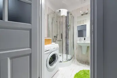 a bathroom with a washing machine and a sink at Wawel Castle Apartment in Kraków