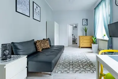 a living room with a black leather couch at Wawel Castle Apartment in Kraków