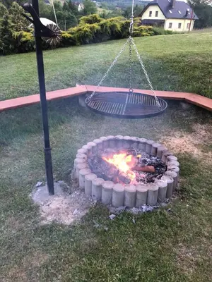 a fire pit in a yard with a swing at Domek w Gaiku in Limanowa